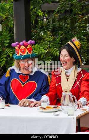 L'homme et la femme d'effectuer à l'extérieur comme le roi et la reine de cœur dans le Mad Hatters Tea Party Banque D'Images