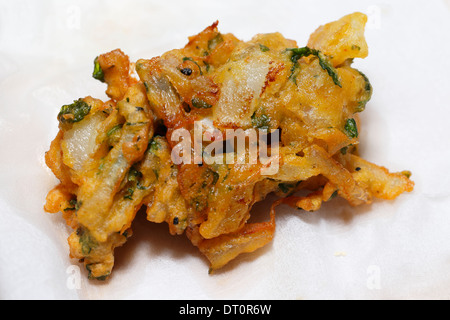 Un oignon bhaji, directement à partir de la casserole, vidange sur une feuille de papier de cuisine Banque D'Images