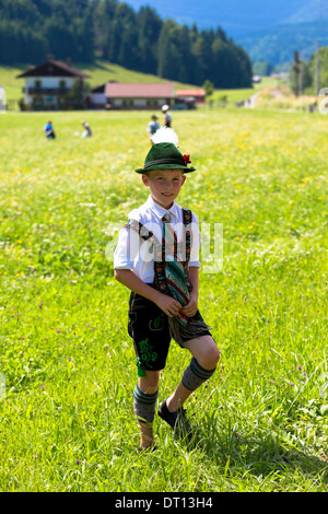 Jeune garçon en costume déambule dans flower meadow lors du festival de la bière traditionnelle dans le village de Klais en Bavière, Allemagne Banque D'Images