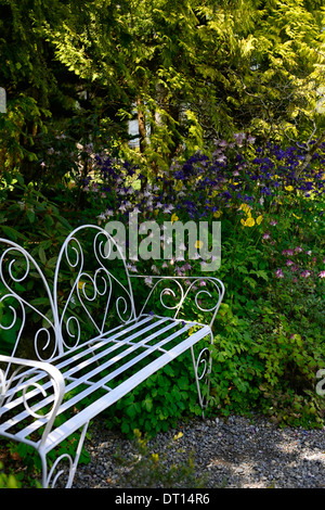 Fer forgé métal blanc banquette blanc mobilier jardin ombragé à l'ombre d''un coin salon patio border Banque D'Images