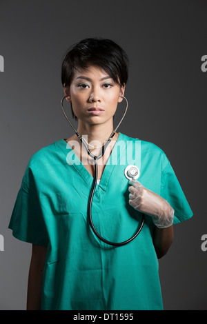 Femme Médecin chinoise dans scrubs chirurgicale avec stéthoscope autour du cou Banque D'Images