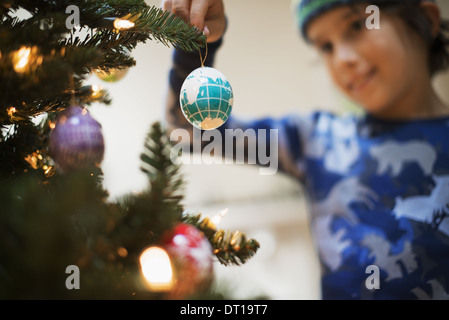 Woodstock, New York USA garçon placer les boules de Noël sur un arbre Banque D'Images