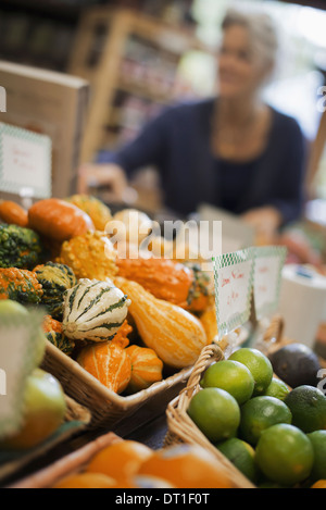 Agriculteur biologique au travail une ferme stand avec un affichage de calebasses et squash de différentes formes et tailles Banque D'Images