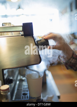 Une personne faire le café barista et mousser le lait à l'aide d'un tuyau de vapeur Coffee shop Banque D'Images