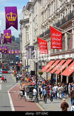 Une rue animée dans la célèbre boutique de jouets Hamleys, Regent Street Banners célébrant l'anniversaire du couronnement de la reine Elizabeth Londres Angleterre Royaume-Uni Banque D'Images