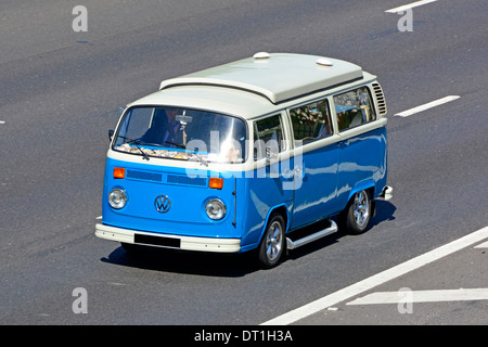 Classic Bleu et blanc emblématique Volkswagen VW Camper van avec toit abaissé l'élévation le long de la conduite d'autoroute England UK Banque D'Images