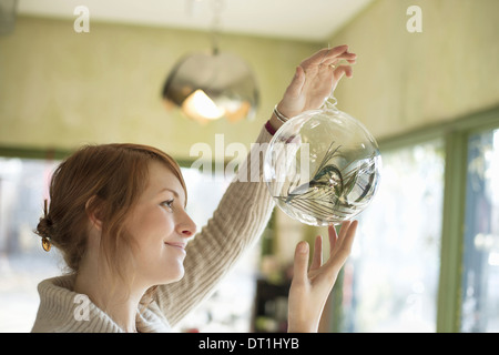 Une femme tenant une grande sphère de verre verre clair avec un objets de décoration intérieur Banque D'Images