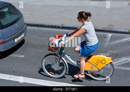 Woman riding a Villo vélo loué le long d'une rue de Bruxelles Banque D'Images