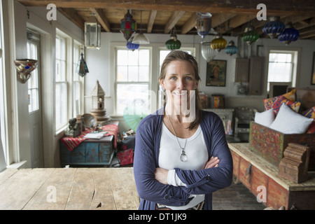 Une femme dans un magasin d'antiquités dans une petite ville avec des objets et meubles du passé Banque D'Images