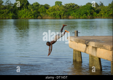 Garçon de plonger dans le fleuve Gambie à partir de la jetée, sur l'île de MacCarthy Janjangbureh, Gambie Banque D'Images