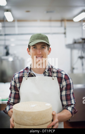 Ferme laitière biologique avec un troupeau de vaches et chèvres laiterie avec de grandes roues de fromage Plateaux de maturation du produit Banque D'Images