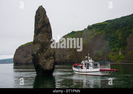 Peu de navires bateau touristique à côté d'un grand monolithe sur la baie d'Avacha près de Petropavlovsk-kamtchatski, du Kamtchatka, la Russie, l'Eurasie Banque D'Images