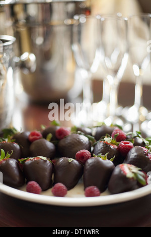 Assiette à dessert de mariage de fraises biologiques trempés à la main de manière artisanale fruits chocolat artisanal avec garniture framboise Banque D'Images