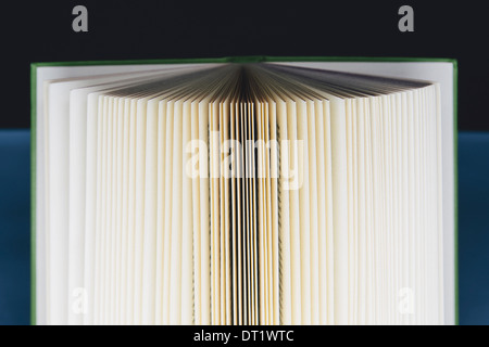 Une couverture rigide imprimé, livre ouvert Pages ventilés avec jaunissement progressif de l'évolution des bords marron et noir dans le centre Banque D'Images