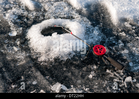 Peu de canne à pêche d'hiver dans le trou Banque D'Images