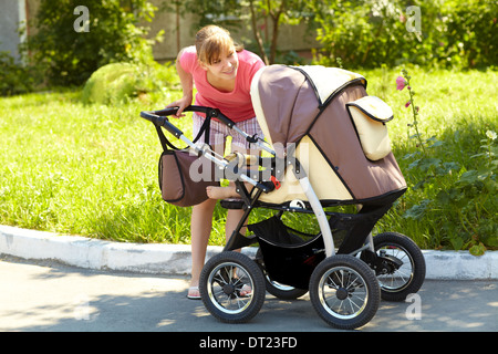 Jeune maman avec une poussette Banque D'Images