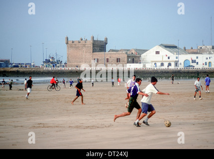 Les jeunes hommes jouent au soccer (football) sur la plage de l'Atlantique à Essaouira, Maroc Banque D'Images