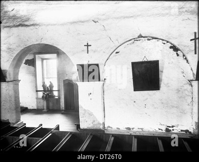 Photographie de l'intérieur de la chapelle de la Mission San Juan Bautista, prise entre 1904 et 1905, mettant en évidence l'architecture historique et l'espace sacré. Banque D'Images