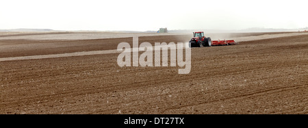 Les tracteurs labourer et planter dans un champ agricole Banque D'Images