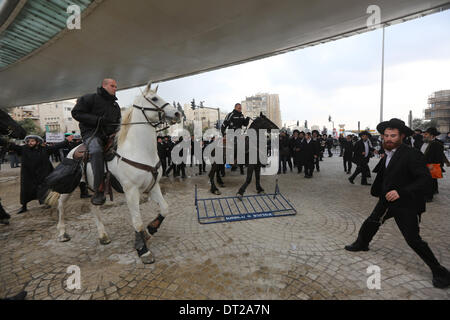 Jérusalem. Feb 6, 2014. Des policiers israéliens disperser une foule de Juifs ultra-orthodoxes au cours d'une manifestation à Jérusalem, le 6 février 2014. Des centaines de juifs ultra-orthodoxes en Israël a bloqué les routes et se sont heurtés à la police jeudi pour protester contre une décision du gouvernement de couper des fonds aux étudiants du séminaire qui éviter le service militaire. tement Crédit : © JINI/Xinhua/Alamy Live News Banque D'Images