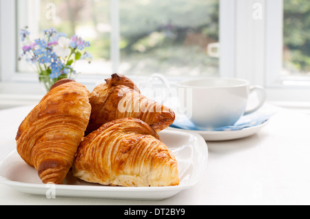 Trois des petits croissants sur la plaque pour le petit déjeuner Banque D'Images