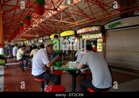 Homme chinois manger des aliments à diners hawker tables Maxwell Food Centre, Singapour Banque D'Images