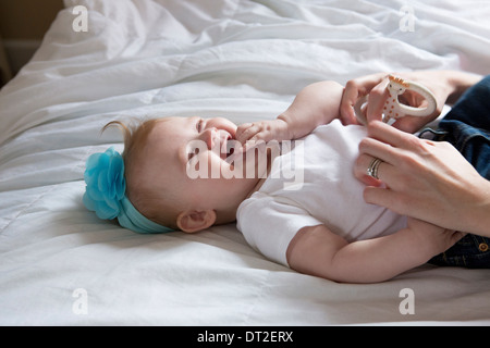 Bébé fille (6-11 mois) lying down on bed Banque D'Images