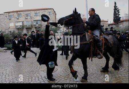 Jérusalem. Feb 6, 2014. Un policier israélien tente de disperser les manifestants juifs ultra-orthodoxes au cours d'une manifestation à Jérusalem, le 6 février 2014. Des centaines de juifs ultra-orthodoxes en Israël a bloqué les routes et se sont heurtés à la police jeudi pour protester contre une décision du gouvernement de couper des fonds aux étudiants du séminaire qui éviter le service militaire. Source : Xinhua/Alamy Live News Banque D'Images