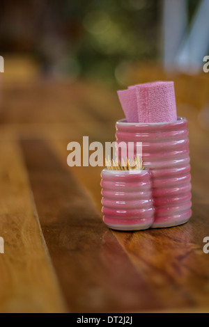 La bouteille de tissu rose placé sur la table en bois. Banque D'Images