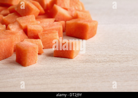 Dés de carottes sur une planche à découper en bois Banque D'Images