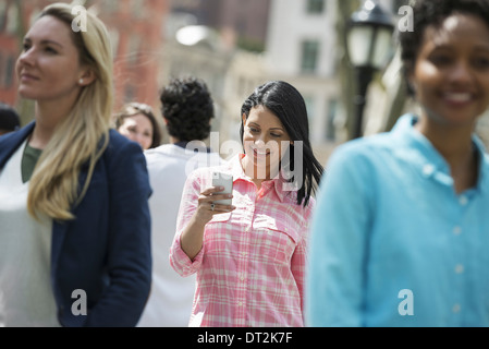 Park trois femmes un contrôle de son mobile phon Banque D'Images