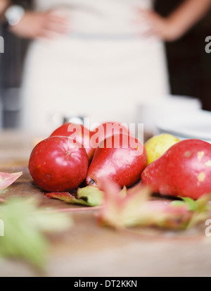 Une table de cuisine intérieure d'un petit groupe de poires biologiques frais et une pile de plaques blanches Banque D'Images