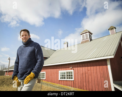 Une ferme biologique en hiver en printemps froid l'État de New York un homme travailler à l'extérieur de la ferme Banque D'Images