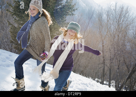 Paysage d'hiver avec neige au sol une femme et un enfant la main dans la main à travers la neige Banque D'Images