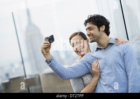 Vue sur Ville jeune couple à prendre des photos avec un téléphone mobile Banque D'Images