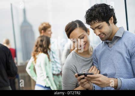 Un jeune couple de prendre des photos avec un téléphone mobile Banque D'Images