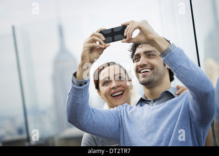 Vue sur Ville jeune couple à prendre des photos avec un téléphone mobile Banque D'Images