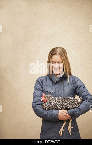 Une femme portant un manteau gris et la tenue d'un poulet Banque D'Images