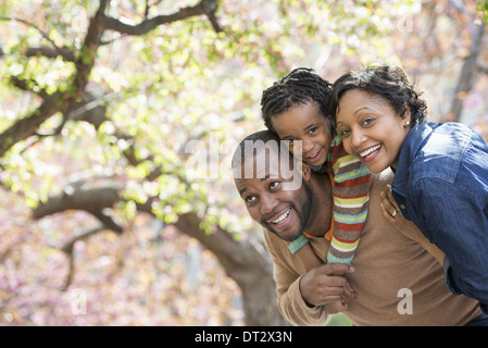 Soleil et fleur de cerisier Un père portant son fils sur ses épaules Banque D'Images