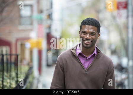 Un jeune homme portant une chemise violette et jersey smiling Banque D'Images