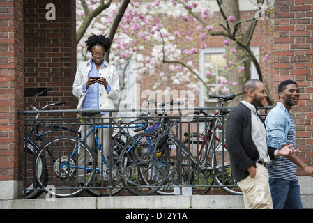 Un support à bicyclettes vélos verrouillé avec un textos femme et deux hommes en marche Banque D'Images