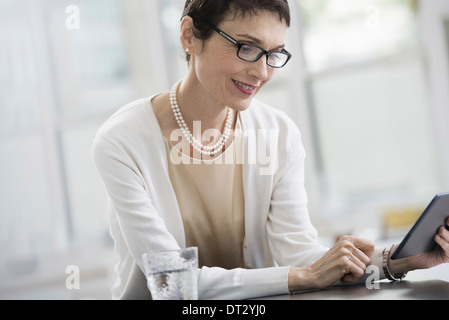 Les jeunes professionnels au travail une femme dans un bureau à l'aide d'une tablette numérique Banque D'Images