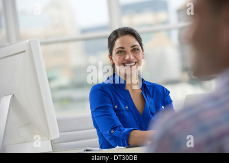 Un homme et une femme assis sur une table à parler Banque D'Images