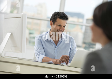 Un homme et une femme assis sur une table à parler Banque D'Images