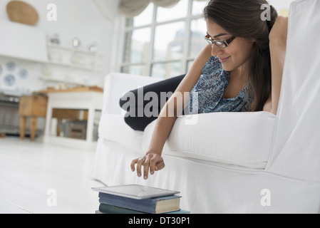 Une personne assise confortablement dans un quartier aéré environnement de bureau à l'aide d'une tablette numérique Banque D'Images