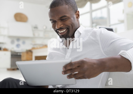 Une personne assise confortablement dans un quartier aéré environnement de bureau à l'aide d'une tablette numérique Banque D'Images