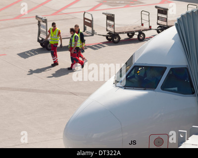 Les travailleurs de l'équipe au sol passe par un avion de passagers stationné à l'Aéroport International de Zurich Kloten après le chargement / déchargement des bagages enregistrés Banque D'Images