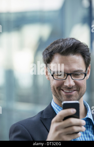 Un homme contrôler son téléphone cellulaire Banque D'Images