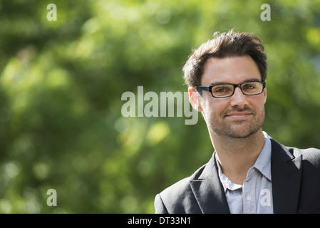 Un homme aux cheveux noirs courts et verres Smiling at the camera Banque D'Images