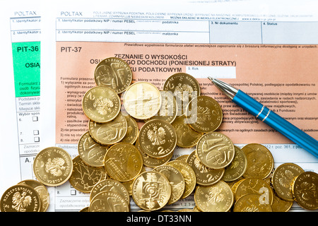 En remplissant le formulaire d'impôt sur le revenu des particuliers polonais fosse avec de l'argent et un stylo. Banque D'Images